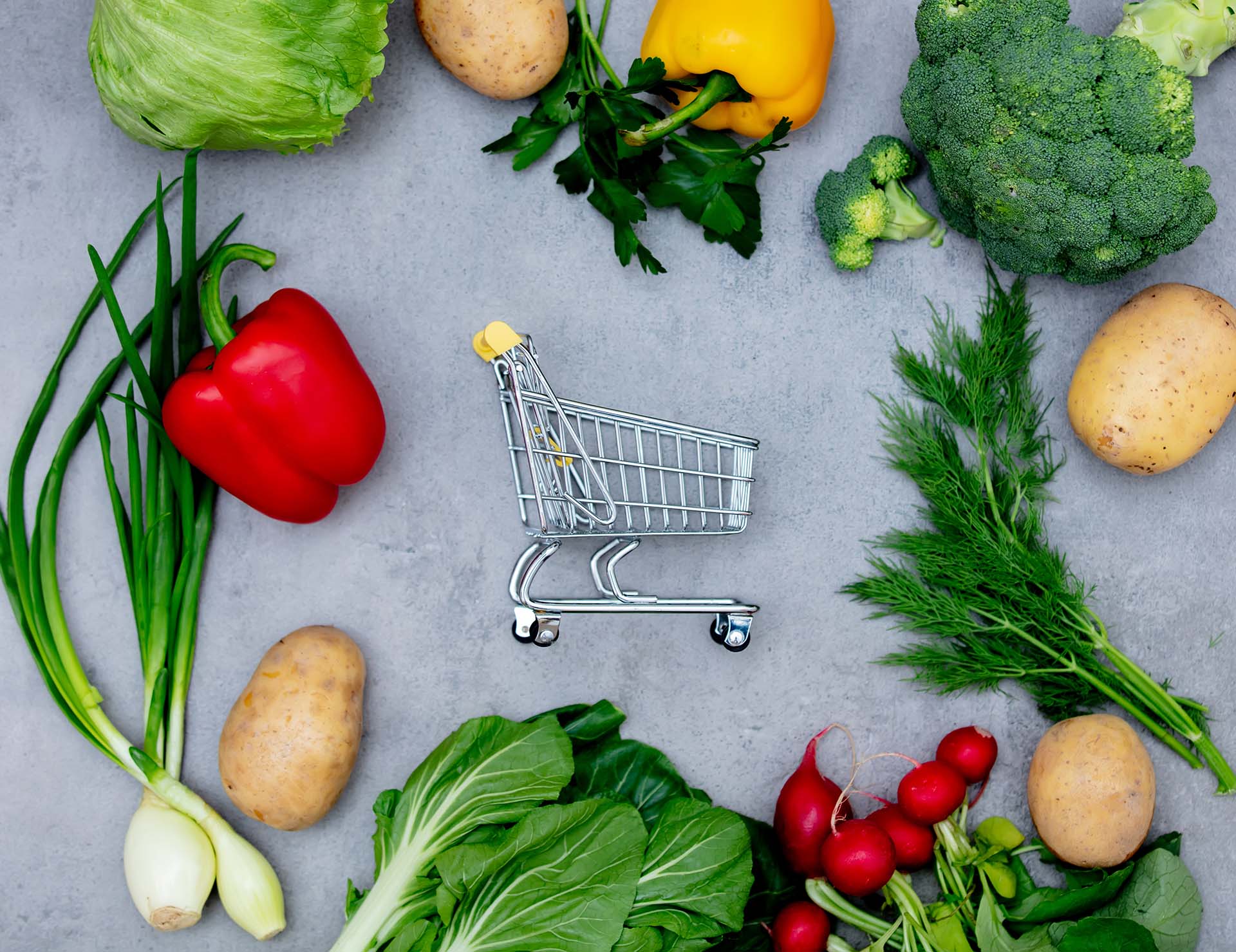 Supermarket cart and vegetables on a table