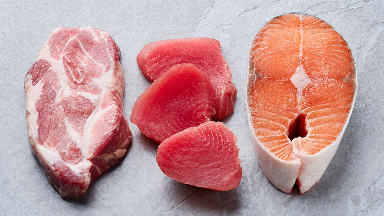 Salmon tuna and pork steak on gray background